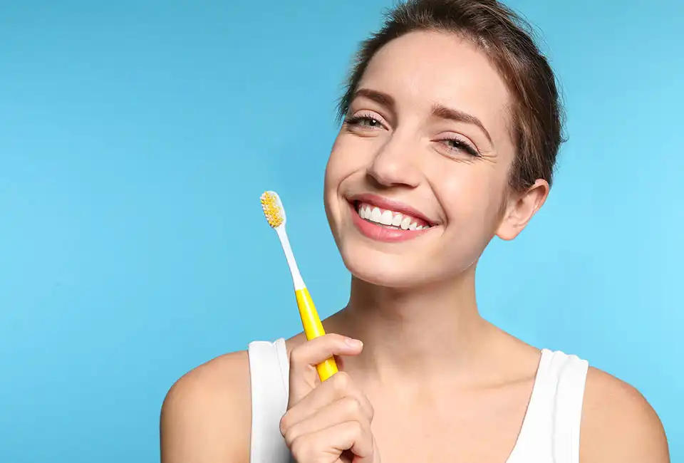 Female with tooth brush taking care of her oral health in Lancaster, CA